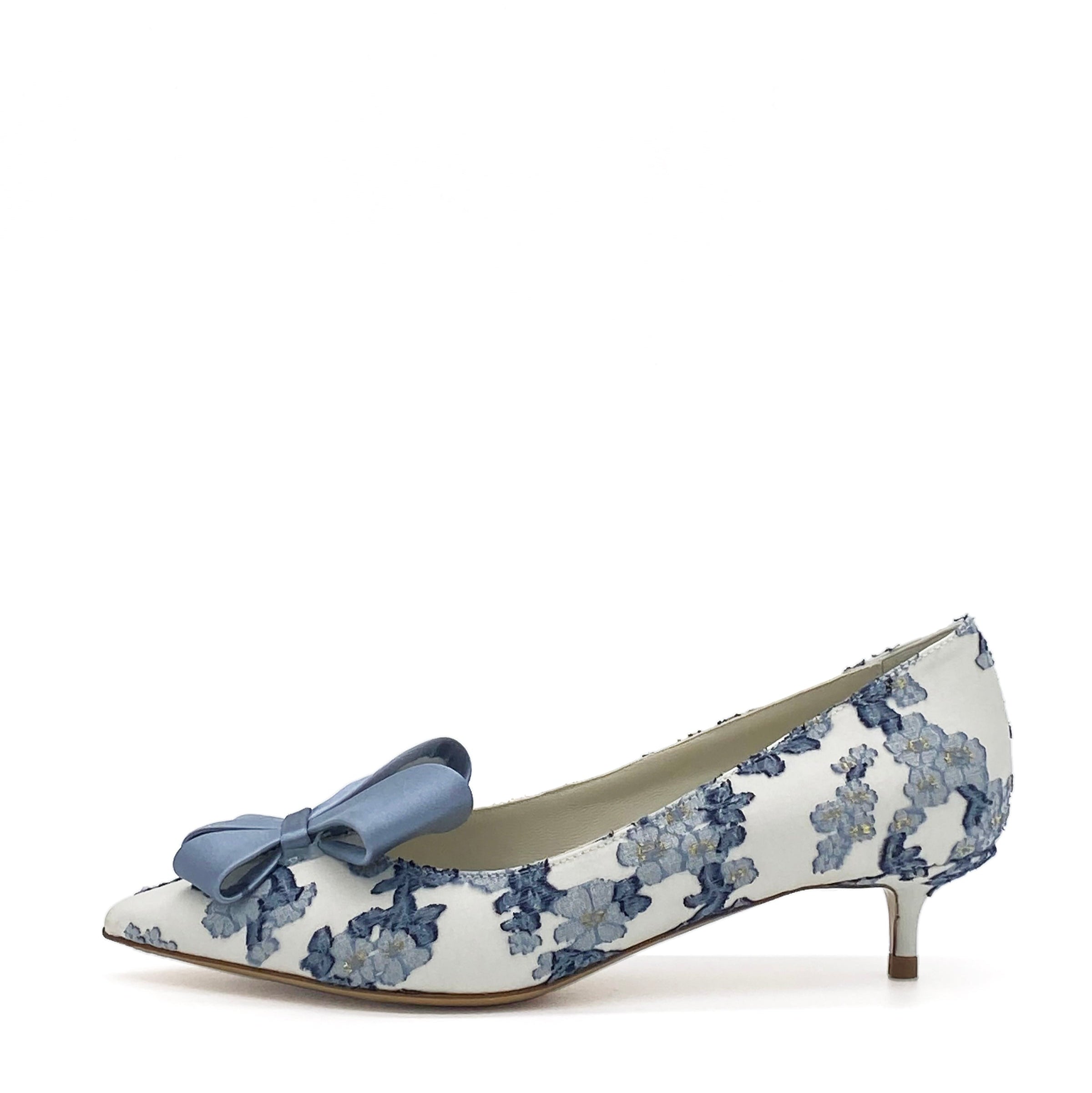 White shoe with blue floral pattern and bow on a white background