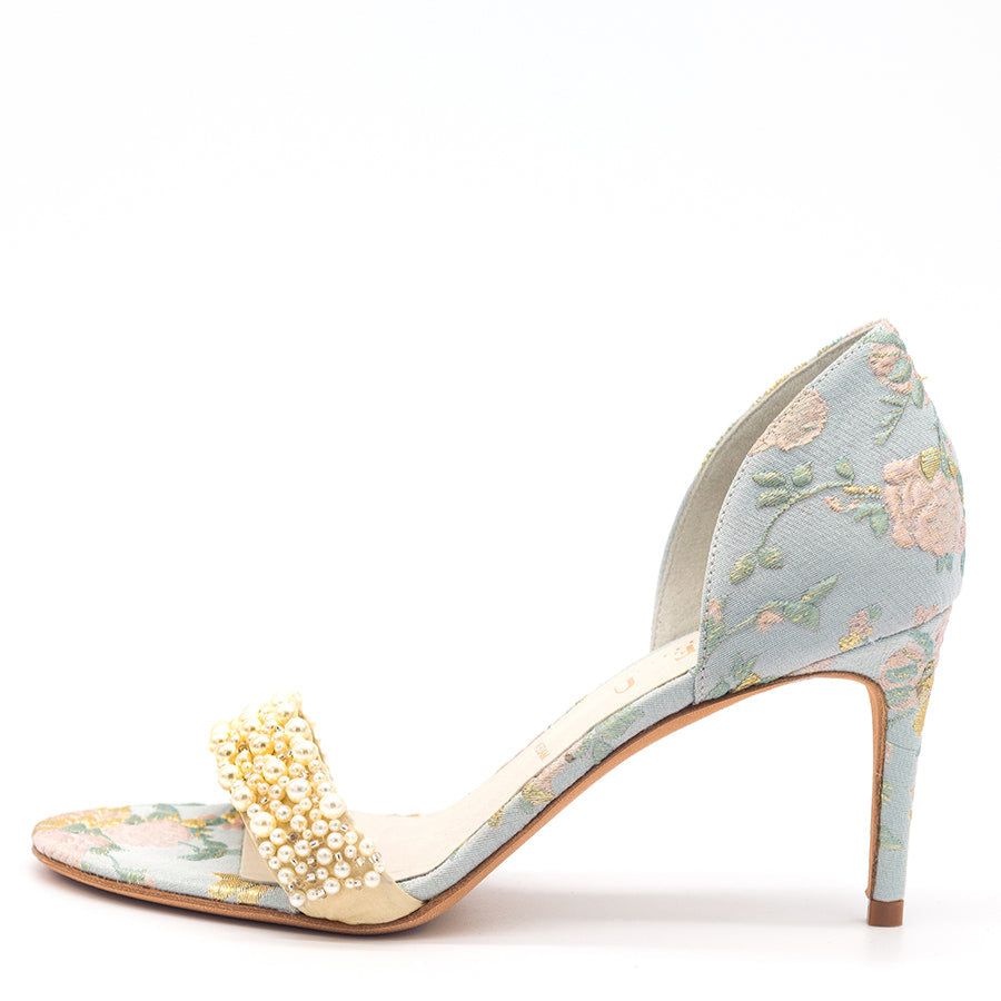 A satin high-heeled sandal with a floral pattern and pearl embellishments, likely made of satin and pearl upper with a leather insole, on a white background.
