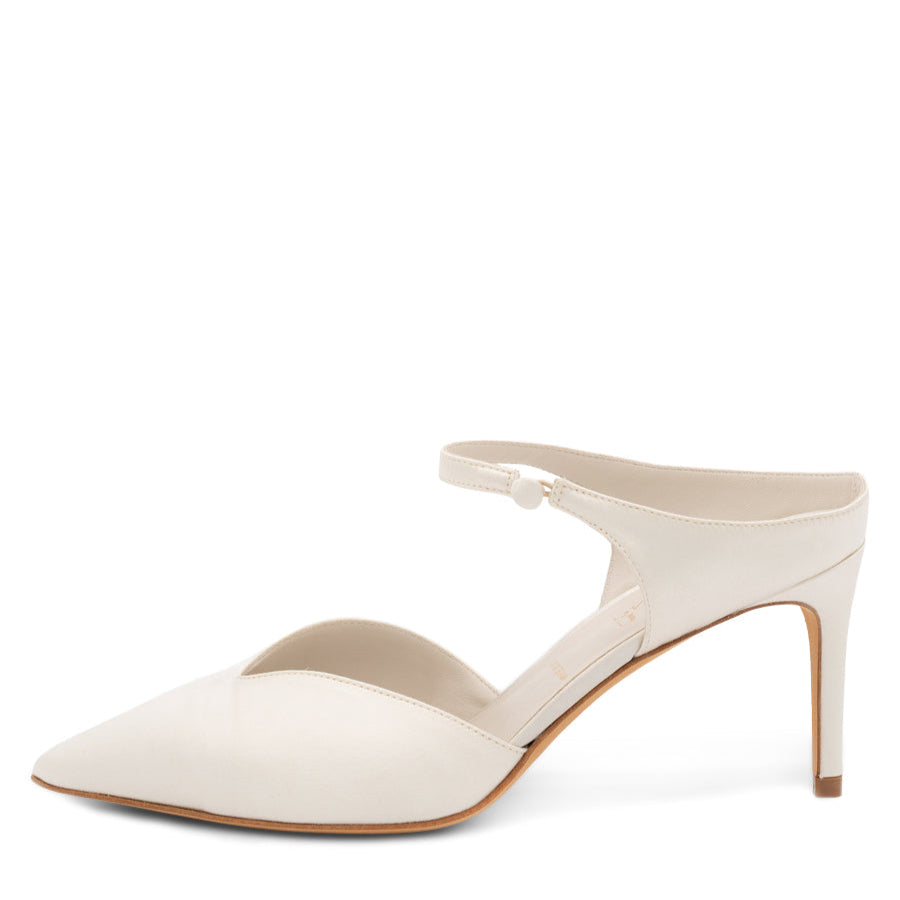 An off-white pointed toe satin pump with a ankle strap and 3 inch heel.