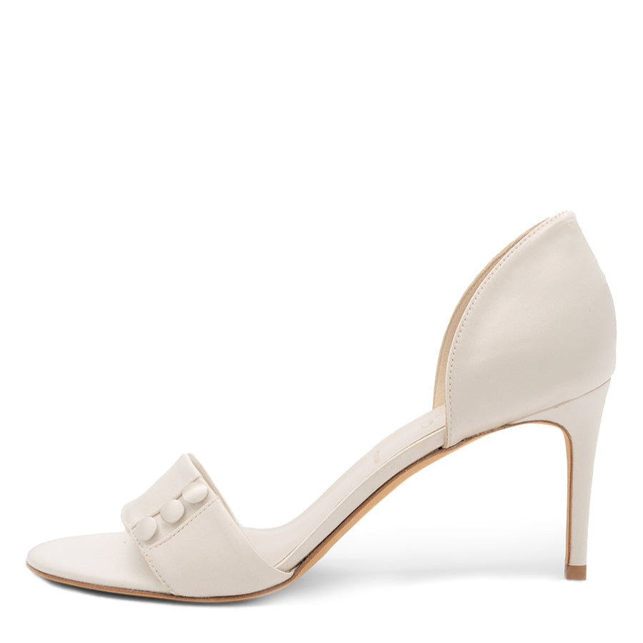 A satin pump with button details and a heel.