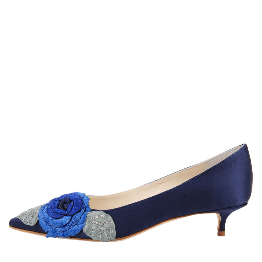 A navy satin pointed-toe heel with floral detailing on the top