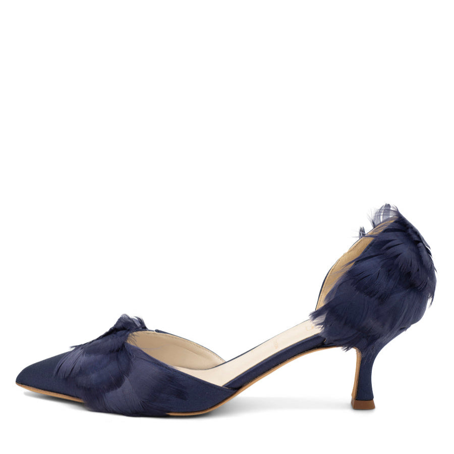 A navy blue kitten heel pump with a pointed toe and feather detail.