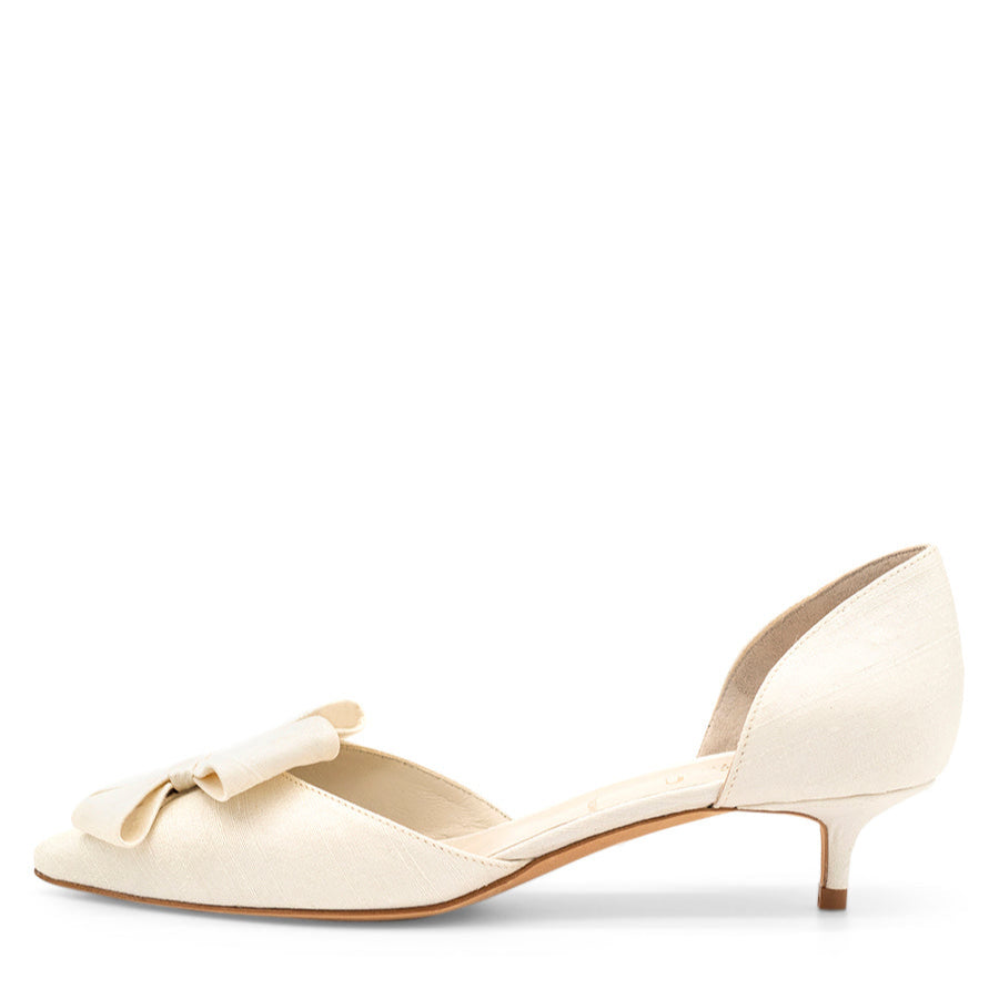 A white pointed toe kitten heel d'Orsay evening shoe with a fabric upper, leather insole, and sole.