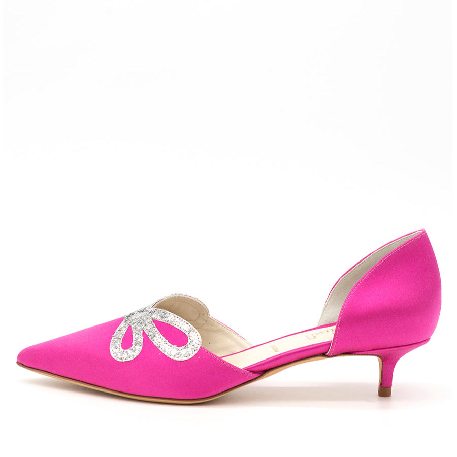 A bright pink kitten heel shoe with a pointy toe and glitter embellishment on the vamp, set against a white background.